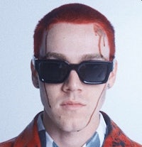 a man with red hair wearing a red jacket and sunglasses